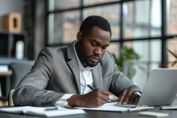 Male at desk, using laptop