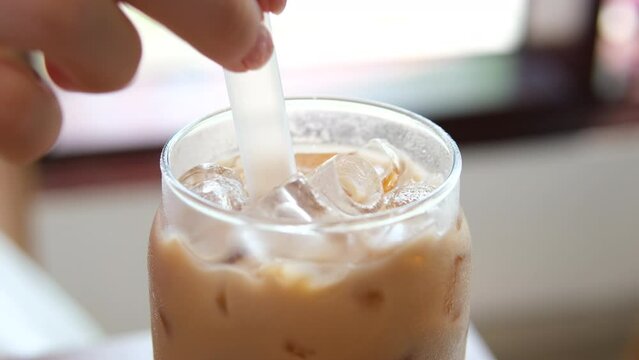 add ice Iced latte in warm weather tropical climate stir delicious drink with coffee