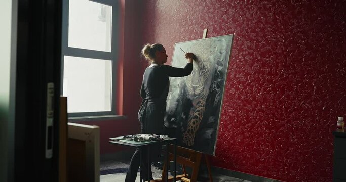 Woman Painting Leopard on Red Studio Wall