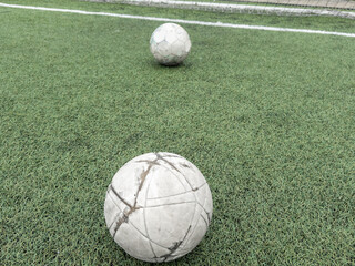 Green grass and white border lines on football ground. Soccer field on artificial turf. Artificial green grass texture. Artificial football field in an open stadium