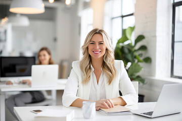 portrait of a businesswoman in white suit sitting in the office smiling at camera
