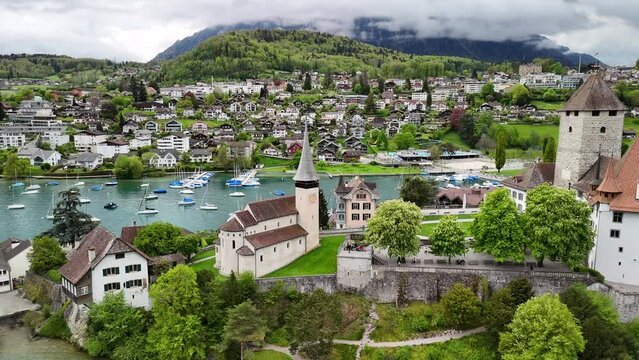 by Spiez Castle ( by Lake Thun (Thunersee), a lake in the Bernese Alps, Spiez Marina , Castle Church in Spiez , Panoramic Train Route (Panorama Express) drone, aerial