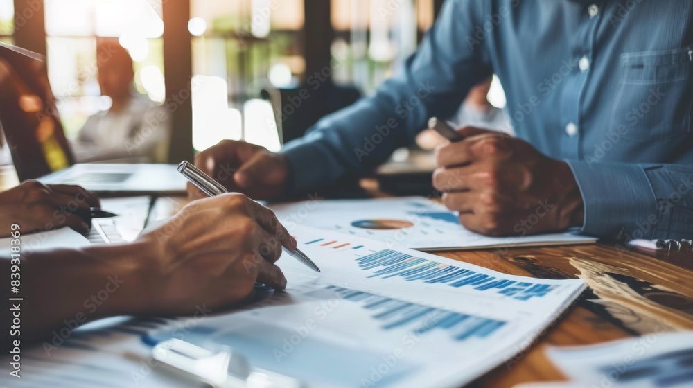 Fototapete a financial advisor discussing investment strategies with a client, using business graphs and charts