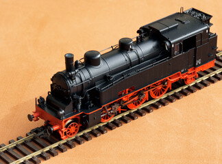 Toy locomotive and railroad with selective focus effect.