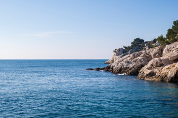 Mediterranean sea with a rocky coast and calm water. Copy space for any graphic or text in the blue...