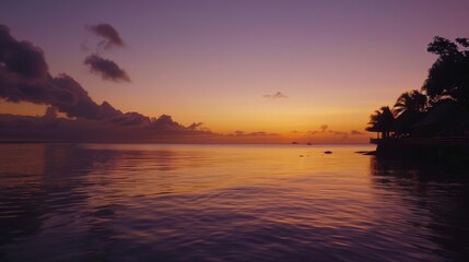 Fototapeta premium A picturesque sunrise over calm waters, with the first light of dawn painting the sky in soft hues of orange and purple