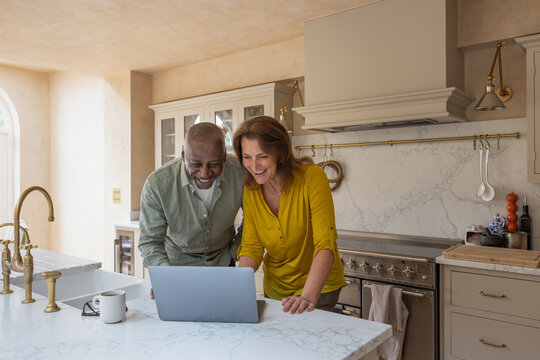 Senior couple at home on a videocall with family using a laptop