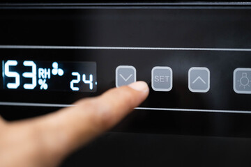 Naklejka premium Finger pressing down button on digital control panel
