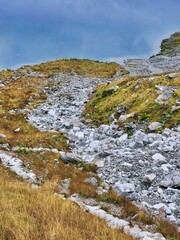 View of lake surrounded by mountains and clear blue sky. Sand dune and vegetation. Nature landscape mountain parks outdoor tree green river stone rock forest. Seasonal natural scene