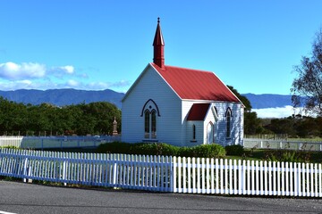 Small church surrounded by a white fence
