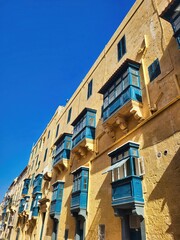 Typical architectural details of the old town. Icicles on the roof of the old house. A closeup of buildings with a blue sky background. A group of windows on the side of an art deco building