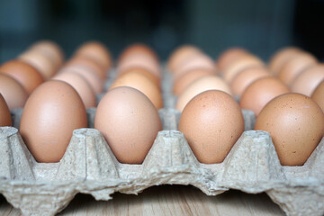 Chicken eggs in egg cartons on a wooden table	