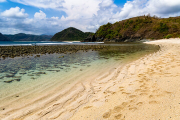 Rocky, tropical beach surrounded by blue ocean (Semeti Beach, Lombok)