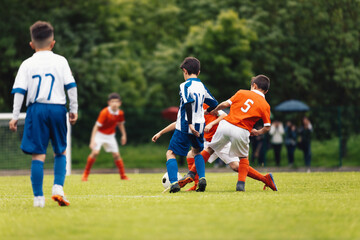 Football Teams Compete in Youth Soccer League. Children Play Soccer Match Outdoor. Group Of Teenage Soccer Players Kicking Soccer Ball on Grass Pitch