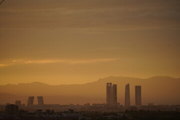 Paisaje y horizonte de la ciudad de Madrid con siluetas de edificios y monta&ntilde;a de fondo 