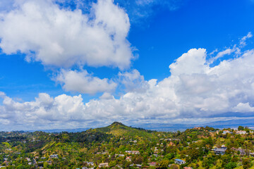 Residential Homes in Hollywood Hills Under Thick Layer of White Clouds on Blue Sky