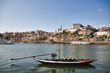 PORTO, PORTUGAL - MAY 12, 2020: Traditional Wine Boat in Douro River, Oporto. Porto, Portugal old town skyline from Dom Luis bridge on the Douro River