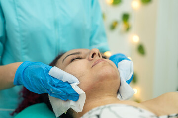 spa therapist applying a facial mask to a client during a beauty treatment at the spa