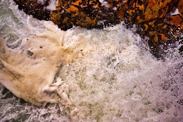 Ocean waves crashing on rocks on a bright day. Portugal