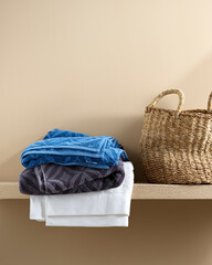 colored towels near the laundry basket on a bright background