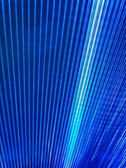 Fototapeta premium Natural green background, closeup tropical palm leaf. Only blue. Blue metal scaffold on the construction building. Blue folds background. Multicolored linear texture. Metal sheet background