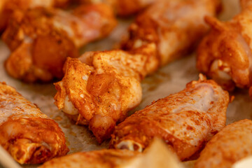 Raw chicken wings in marinade on protwin close-up