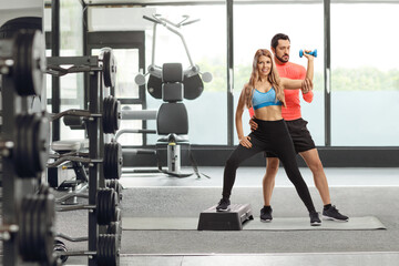 Male trainer exercising with a young woman