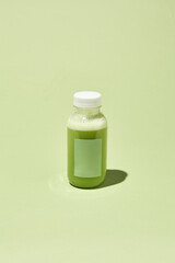 Minimalist Green Smoothie Bottle on Pastel Background - Creative Conceptual Pattern with Colorful Shadows