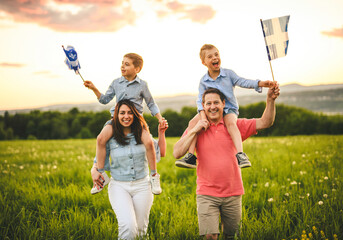 A Patriotic family waving Quebec flags on sunset