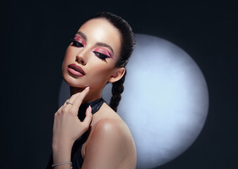 Beautiful woman with amazing makeup, closeup portrait on dark background. 