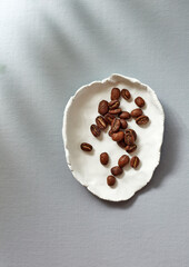 coffee beans are scattered in a plate on the table