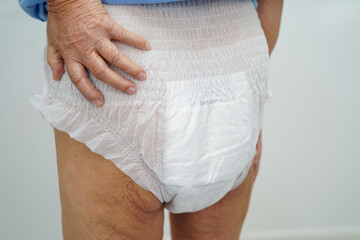 Asian elderly woman wearing diaper for loss of bladder urinary incontinence control.