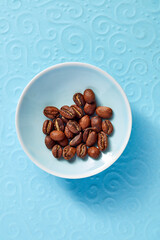 coffee beans in a plate on the table on a bright background