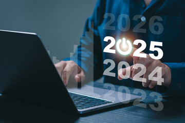 Start new year 2025, Business Planning and goal Concept. A Businessman is working on a laptop and pointing at a virtual screen that displays the year 2025. new beginning.  New Technology.