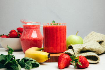 Fruit smoothie in transparent cups. Red strawberry smoothie on a concrete background. The concept of healthy eating. Front view