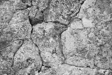 Big crack. Large winding deep crack in an old stone plastered wall. Black and white photo. Close-up. Selective focus. Copy space.
