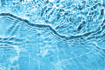Rippled surface of clear water on light blue background, top view