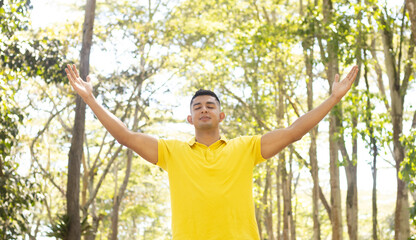 young latin man facing front with arms open worshiping