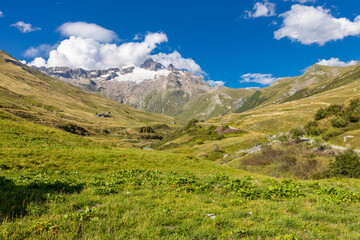 Tour du Montblanc beautiful mountain ladscapes of the Alps green valley, snow summit of Montblanc and rocky peaks of Aiguille du Midi in summer sunny weather blue sky, trekking and hiking in Chamonix