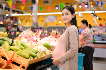 Beautiful pregnant woman shopping healthy food at grocery shop