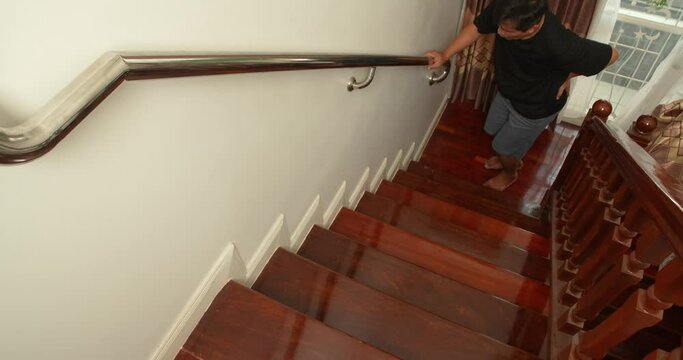 Man suffering from low back pain while walking up the stairs, have a backache, Office Syndrome health problems.
