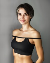 Obraz premium Young slim athletic brunette on a gray background. Active lifestyle, weight loss, motivation.