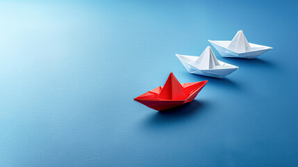 Three paper boats are lined up on a blue surface