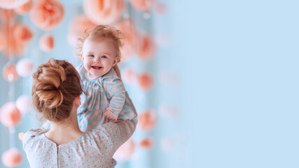 Fototapeta premium Australian mother holding her baby with her arm and lifting up playing fun