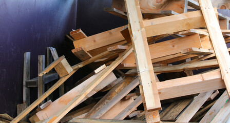 industrial waste container filled with broken wooden pallets ready for recycling at an industrial...