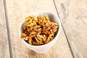 Cracked unshelled walnut in the bowl