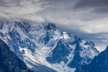 Tour du Montblanc beautiful mountain ladscapes of the Alps green valley, snow summit of Montblanc and rocky peaks of Aiguille du Midi in summer sunny weather blue sky, trekking and hiking in Chamonix