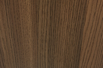 Closeup of a hardwood floor with natural wood grain patterns. The rich brown color is enhanced by a wood stain and varnish, creating a warm and inviting feel.