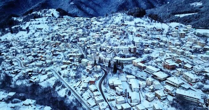 The video showcases snow-covered houses in a picturesque village in the Rhodope Mountains. In the background, the majestic snowy peaks rise, with Mount Snezhanka standing prominently, adding a magical