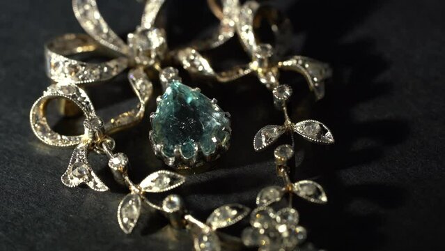 Short video of lightning antique gold brochure with diamonds on black background